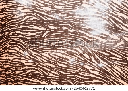 Brown zebra print pattern background with flowing stripes on cream fabric surface. Wild animal print texture perfect for fashion and neutral decorative design projects.
