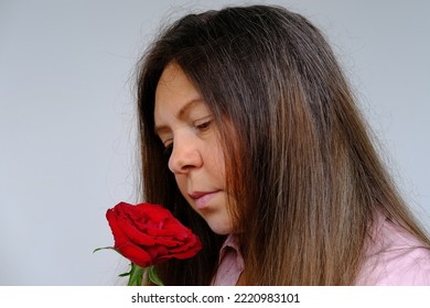 Brown-haired Face, Flower, Red Rose In Hands Of Sad Mature Woman 50 Years Old, Sad Memories, Parting With A Loved One, Mother's, Valentine's Day, Birthday, Selective Focus