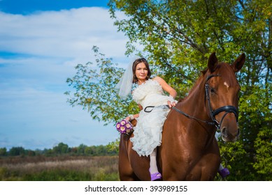 brown-haired woman on a horse, in wedding dress, forest and blue sky on the background