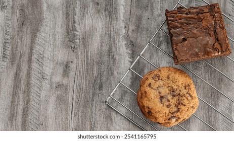 Brownie and chocolate chip cookie cooling on a metal rack over a rustic wooden surface. Perfect for dessert and baking themes. - Powered by Shutterstock