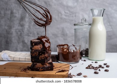 Brownie Pieces On Wooden With Pouring Melted Chocolate Sauce.Chocolate Brownie With Coffee On Wooden.