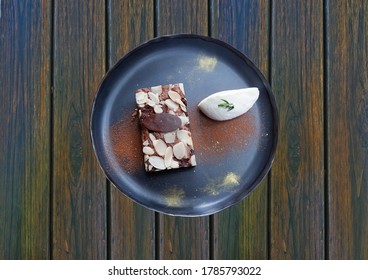 Brownies in a black plate on  dark wooden background in the restaurant