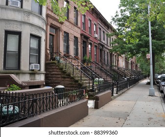 Brownstone Homes Along Residential Neighborhood Sidewalk In Brooklyn New York On Overcast Sky Day