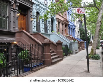 Brownstone Homes Tree Lined Urban Street With No Parking Street Cleaning Sign On Sidewalk Manhattan New York City