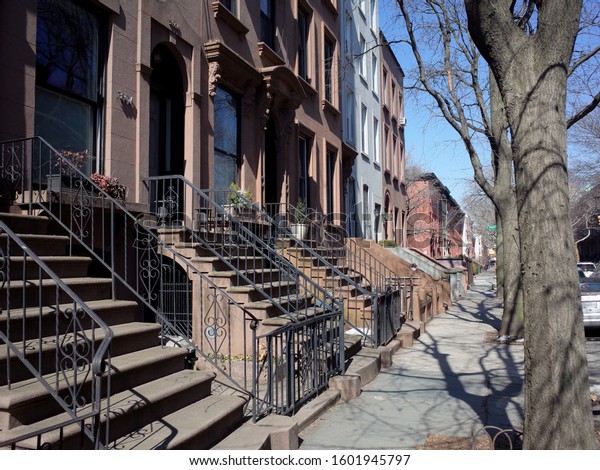 Brownstone houses on a street in the\
up and coming neighborhood of Cobble Hill, Brooklyn,\
NYC