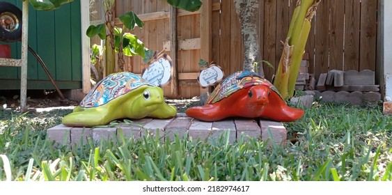 Brownsville TX USA July 10th 2022: Two Turtle-shaped Garden Ornaments And A Wooden Fence In The Background Outside In The Backyard.