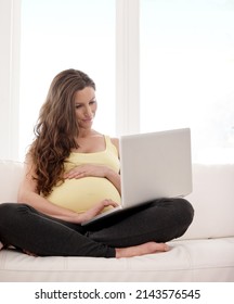 Browsing For Pregnancy Tips. Shot Of A Young Pregnant Woman Working On Her Laptop At Home.