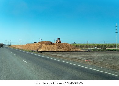 Bruce Highway, Queensland, Australia - August 19, 2019: Council Machinery Compacting Dirt For New Road Construction On Busy Highway