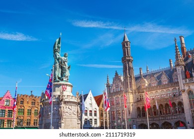 Bruges, Belgium - April 10, 2016: Statue of Jan Breydel and Pieter de Coninck and the flag of Brugge at the Market Square Markt