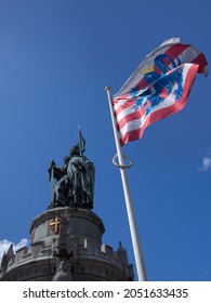 BRUGES, BELGIUM - APRIL 13, 2014:  The Flag of Bruges flying close to the statue of Jan Breydel and Pieter de Coninck