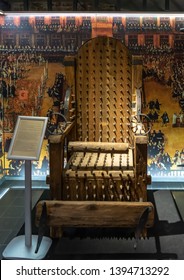 Bruges, Belgium - December 14, 2018: One of the cruel exhibits in Torture Museum Bruges, "Oude Steen" - Chair of Torture. This terrible device of the Middle Ages is covered with spikes to cause pain.