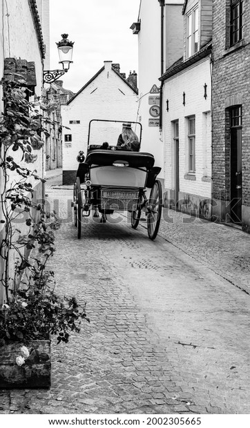 bruges, belgium, july 2021, a carriage that\
rides in the narrow streets of the\
city