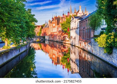 Bruges, Belgium. Panoramic view of the historic city center of Brugge with Groenerei Canal in beautiful golden morning light at sunrise, province of West Flanders.