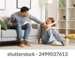 Bruised young woman and her drunk husband at home. Domestic violence concept