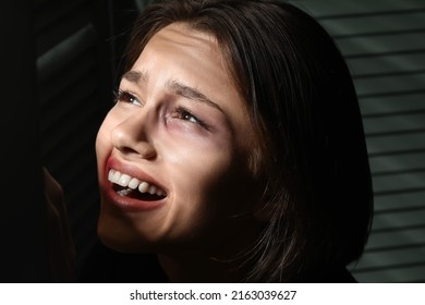 Bruised Young Woman Hiding In Closet At Home, Closeup. Domestic Violence Concept