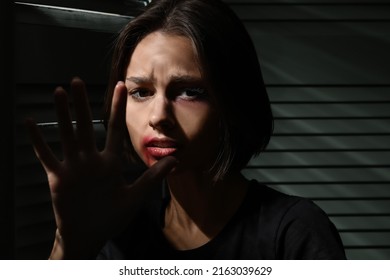 Bruised Young Woman Hiding In Closet At Home, Closeup. Domestic Violence Concept