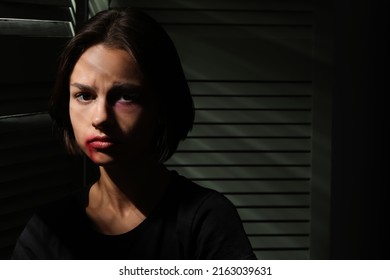 Bruised Young Woman Hiding In Closet At Home. Domestic Violence Concept