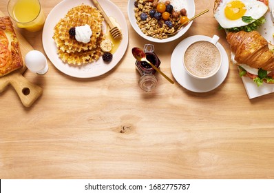 Brunch Flatlay On Wooden Table. Healthy Sunday Breakfast With Croissants, Waffles, Granola And Sandwiches. Banner Composition With Copy Space