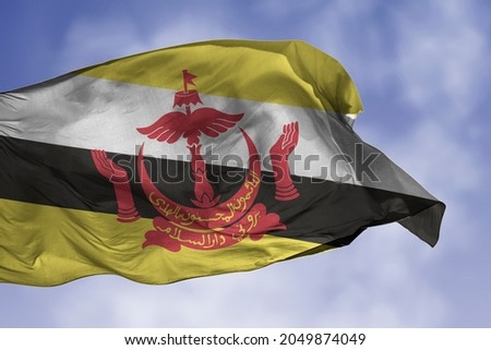 Brunei flag isolated on the blue sky with clipping path. close up waving flag of Brunei. flag symbols of Bruneian.