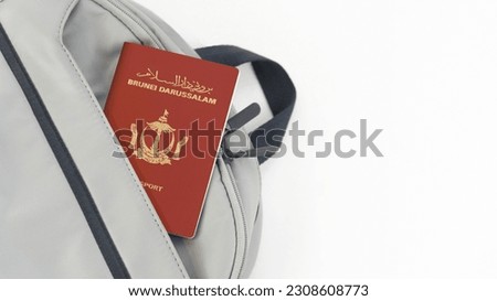 Brunei Passport on a grey Travel Bag with white background copy space - Bruneian
