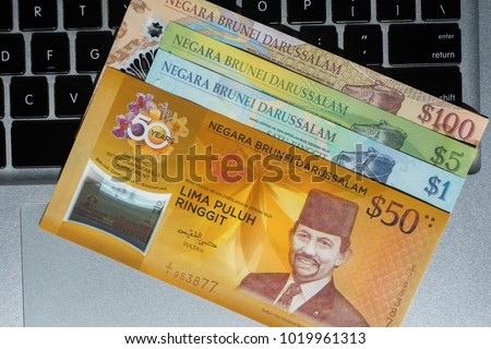 The bruneian Currency - dollar - on laptop background, copy space
