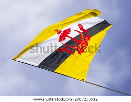Brunei's flag is isolated on a sky background. flag symbols of Brunei. close up of a Bruneian flag waving in the wind.
