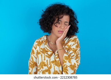 Brunette Arab Woman Wearing Hawaiian Shirt Over Blue Background With Toothache