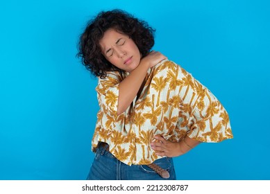 Brunette Arab Woman Wearing Hawaiian Shirt Over Blue Background Got Back Pain