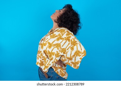 Brunette Arab Woman Wearing Hawaiian Shirt Over Blue Background Got Back Pain