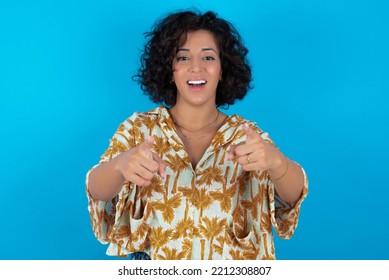 Brunette Arab Woman Wearing Hawaiian Shirt Over Blue Background Cheerful And Smiling Poiting At Camera