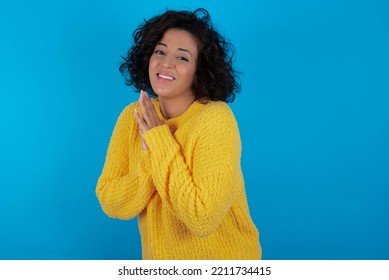 Brunette Arab Woman Wearing Yellow Sweater Over Blue Background , Feeling Happy, Smiling And Clapping Hands, Saying Congratulations With An Applause.