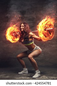 Brunette athletic female doing squats with burn barbell on her shoulders.