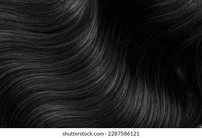 Brunette or black hair. Female long dark hair in black. Beautifully laid curls. Closeup texture in a dark key. Hairdressing, hair care and coloring. Shading gray hair. Background with copy space. - Shutterstock ID 2287586121