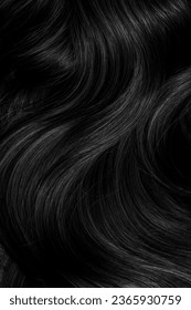 Brunette or black hair. Female long dark hair in black. Beautifully laid curls. Closeup texture in a dark key. Hairdressing, hair care and coloring. Shading gray hair. Background with copy space. - Shutterstock ID 2365930759