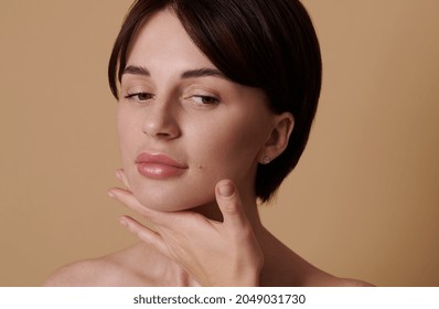 Brunette Caucasian Woman Performing Lifting Rejuvenating Massage On Her Neck,posing Against Beige Background With Copy Space. Skin Body Care, Face Gymnastics, Cosmetology, Aesthetic Medicine Concept