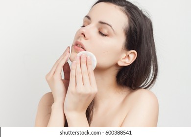 Brunette with cream on face and with sponge