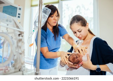 Brunette female breastfeeding consultant teaching new mom to breastfeed newborn baby in hospital room. Pain while feeding. Concept of lactation infant feeding. - Shutterstock ID 2221066191