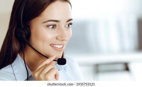 Brunette Female Customer Service Representative In A Headset Is Consulting Clients Online. Call Center And Business People Concept