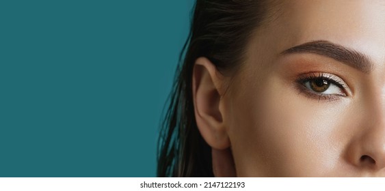 brunette female eyes. Vision control or visual acuity laser surgery concepts, close-up, blue background