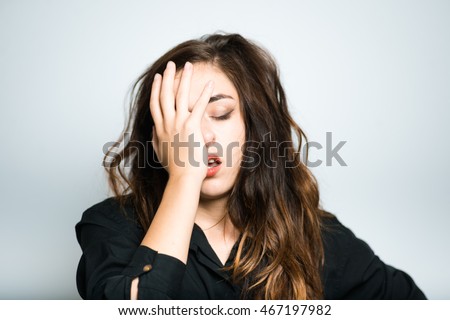 brunette girl is bored, dressed in black, isolated on white background