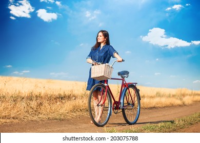 Brunette Girl  With  Bycicle On Countryside Road.