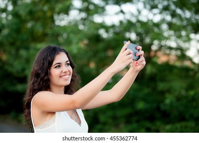 Brunette girl getting a photo with cellphone in park - Shutterstock ID 455362774