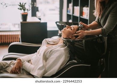 Brunette girl getting ready to wash her hair at the hair salon - Powered by Shutterstock