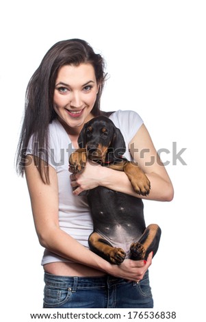 Brunette girl with her doberman puppy isolated on white background