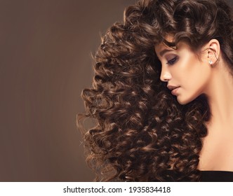 Brunette  girl with long  and   shiny curly  hair .  Beautiful  model woman  with wavy hairstyle 