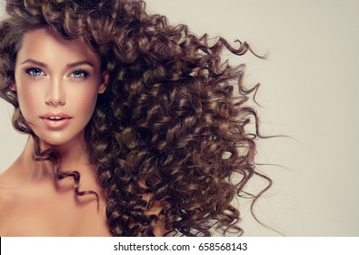 Brunette  Girl With Long  And   Shiny Curly  Hair .  Beautiful  Model Woman  With Wavy Hairstyle .