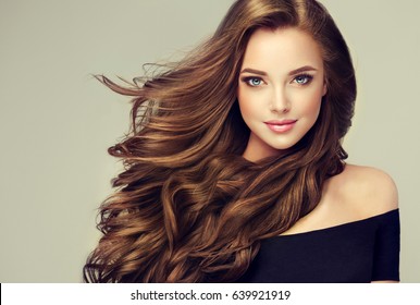 Brunette  girl with long  and   shiny wavy hair .  Beautiful  model with curly hairstyle . - Shutterstock ID 639921919