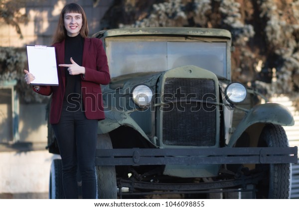 brunette girl\
on the background of a car\
advertises