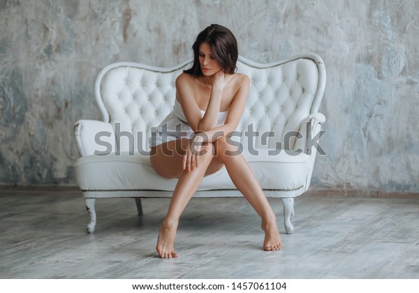 Brunette Girl Sitting On White Couch Stock Photo Edit Now 1457061104