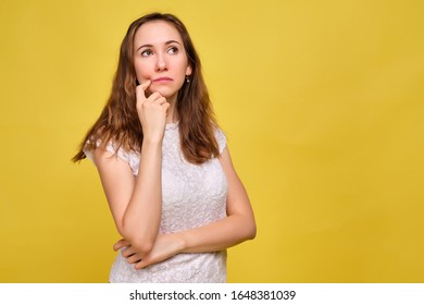 The Brunette Girl In Summer Clothes On A Yellow Background Thought About The Test Results. Close Up.